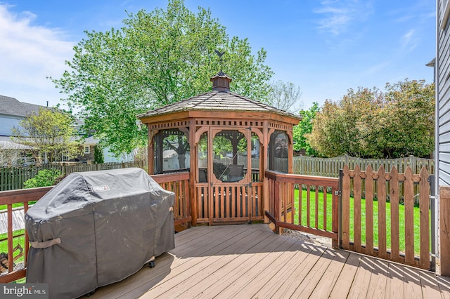 wooden deck with a gazebo, a fenced backyard, a yard, and a grill