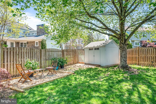 view of yard featuring a storage unit, an outdoor structure, a patio area, and a fenced backyard