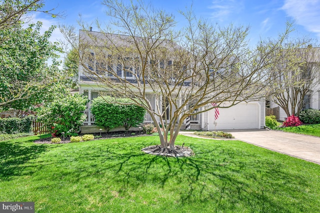 view of front of house featuring fence, a garage, driveway, and a front yard