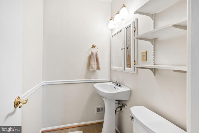 half bathroom featuring toilet