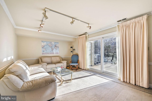 living room with carpet floors, ornamental molding, and visible vents