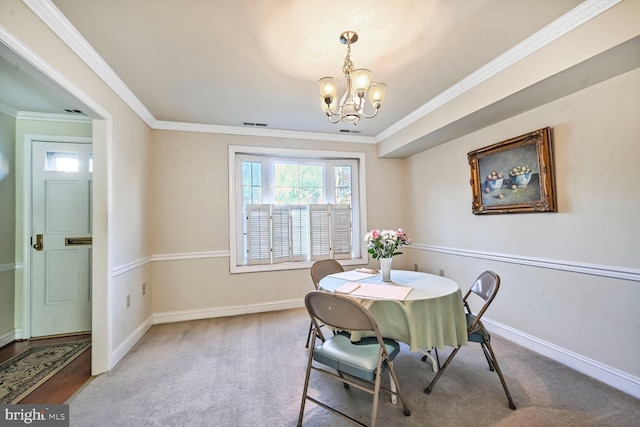 carpeted dining room with baseboards, a notable chandelier, visible vents, and ornamental molding