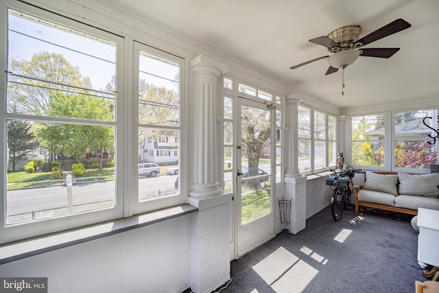 sunroom / solarium featuring decorative columns, carpet floors, and a healthy amount of sunlight