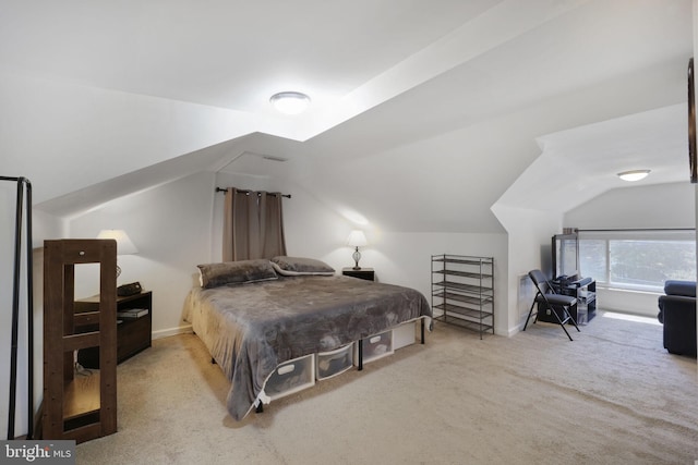 bedroom with baseboards, vaulted ceiling, and carpet