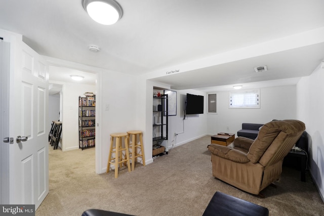 carpeted living area featuring visible vents and baseboards