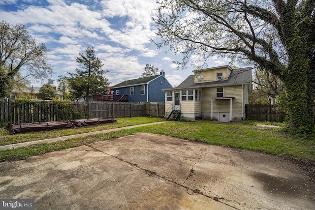 back of house with a yard, entry steps, and fence