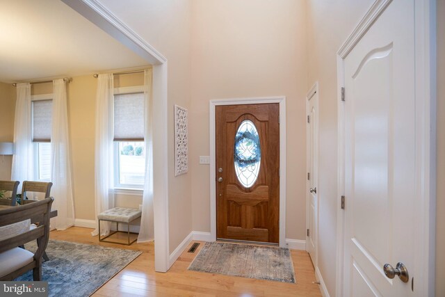 entryway with visible vents, light wood-type flooring, and baseboards