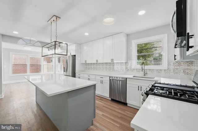 505 N Naylor St, Alexandria, VA 22304 - kitchen with stainless steel appliances, a sink, light countertops, a kitchen island, and tasteful backsplash