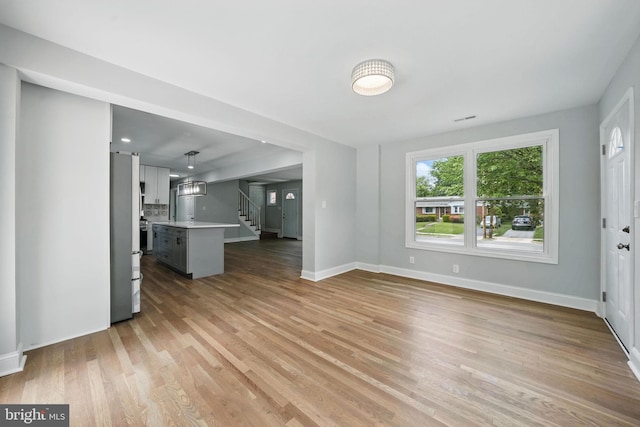 505 N Naylor St, Alexandria, VA 22304 - unfurnished living room featuring stairway, light wood finished floors, and baseboards