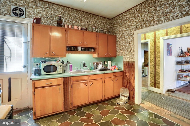 kitchen with light countertops, a sink, white microwave, and open shelves