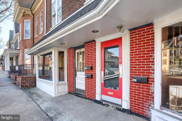 view of exterior entry featuring brick siding