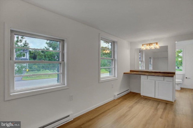 interior space with vanity, toilet, wood finished floors, and a baseboard radiator