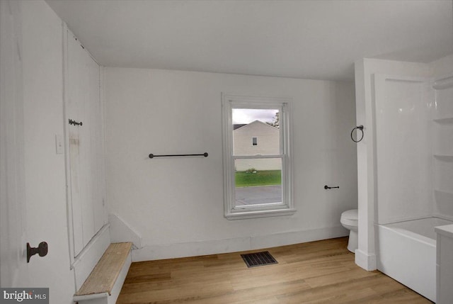 bathroom with toilet, wood finished floors, visible vents, and baseboards
