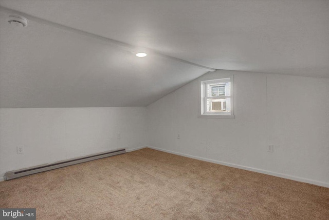 additional living space with a baseboard heating unit, baseboards, carpet flooring, and vaulted ceiling