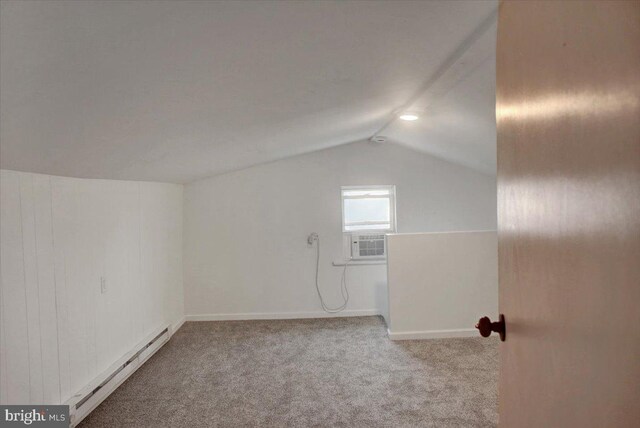 additional living space featuring vaulted ceiling, cooling unit, carpet floors, and a baseboard radiator