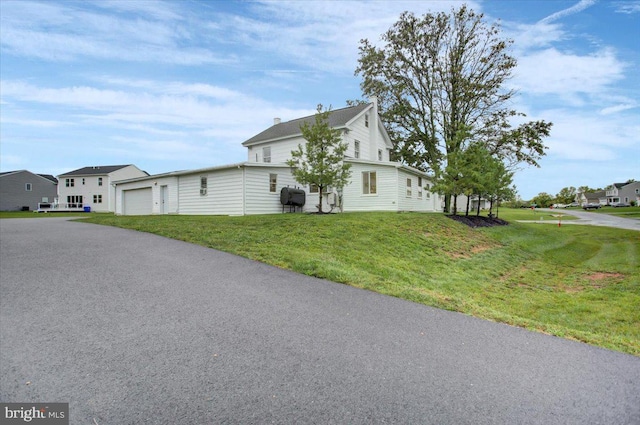 view of side of home featuring a yard and a garage
