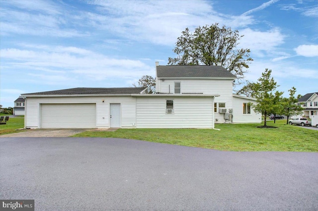 view of front of house featuring a garage, a front lawn, and driveway