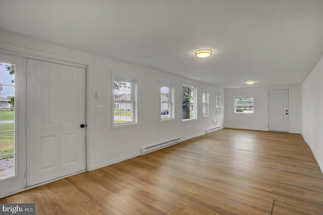 entrance foyer featuring light wood finished floors, a baseboard heating unit, and baseboards
