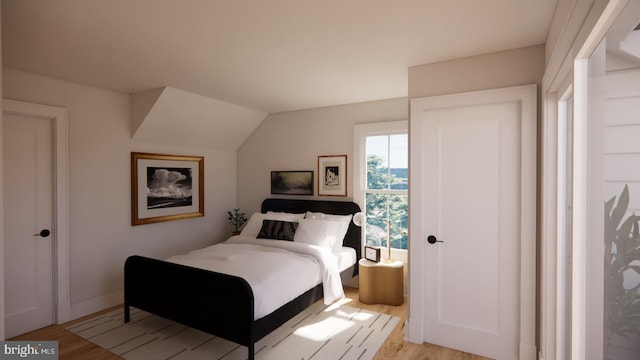 bedroom featuring light wood-type flooring and vaulted ceiling