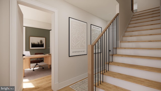 staircase featuring baseboards and wood finished floors