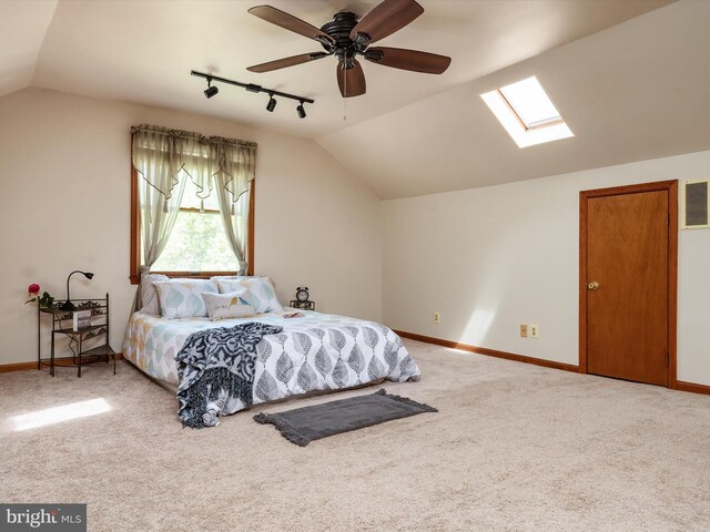 carpeted bedroom featuring track lighting, baseboards, lofted ceiling with skylight, and visible vents