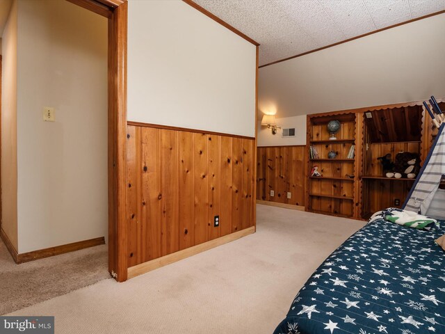 carpeted bedroom featuring visible vents, wood walls, and wainscoting