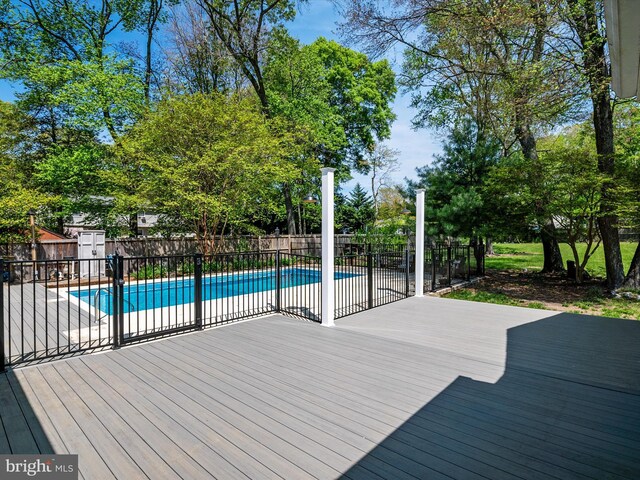 deck featuring a fenced in pool and a fenced backyard