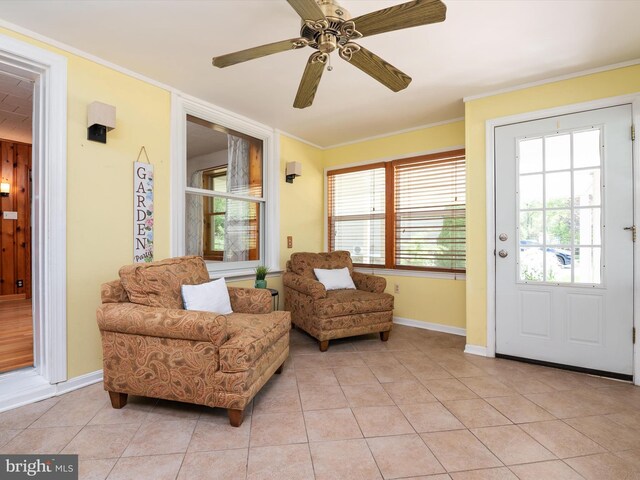 living area featuring baseboards, a ceiling fan, crown molding, and light tile patterned flooring