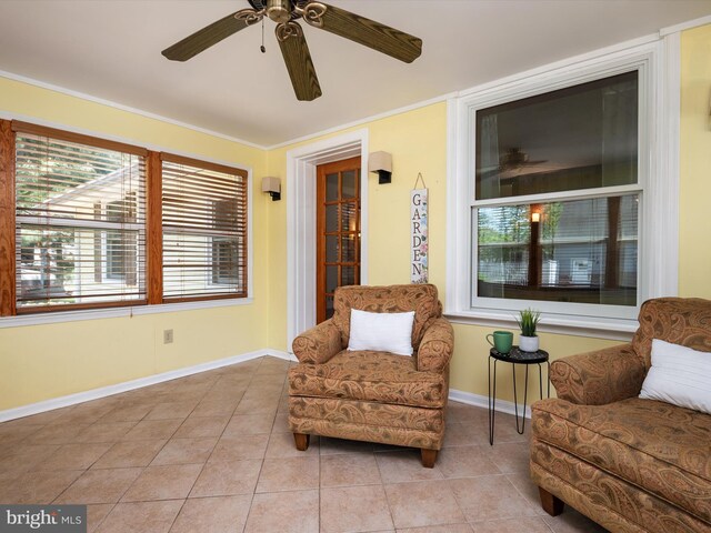 living area featuring a ceiling fan, baseboards, and tile patterned floors