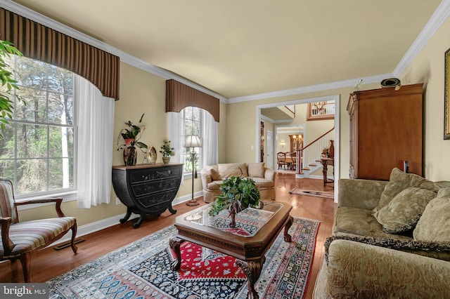 living room with stairway, a healthy amount of sunlight, crown molding, and wood finished floors