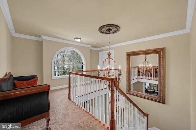 corridor with baseboards, an upstairs landing, a chandelier, carpet floors, and ornamental molding