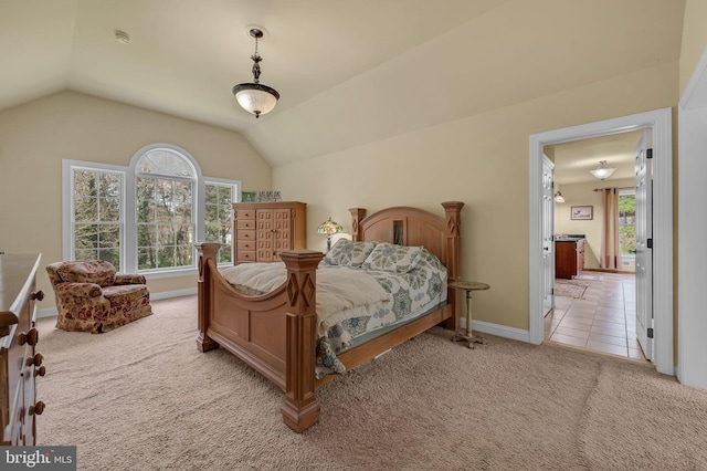 bedroom featuring lofted ceiling, baseboards, and light colored carpet
