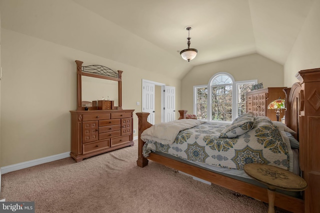 carpeted bedroom featuring lofted ceiling and baseboards