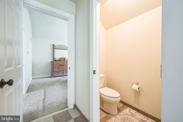 bathroom with toilet and baseboards