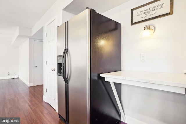 kitchen featuring light countertops, baseboards, dark wood-style floors, and refrigerator with ice dispenser