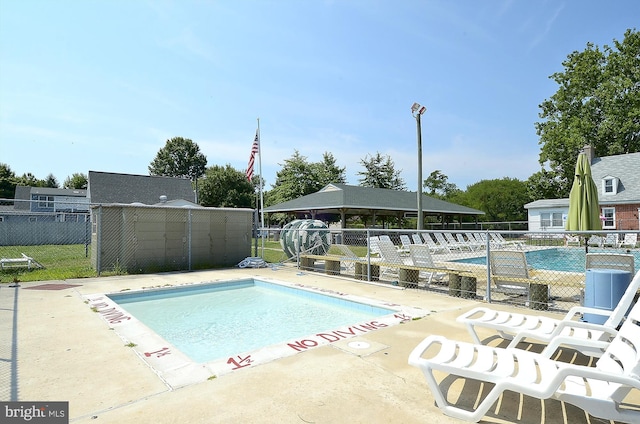 pool with fence, a patio, and a gazebo