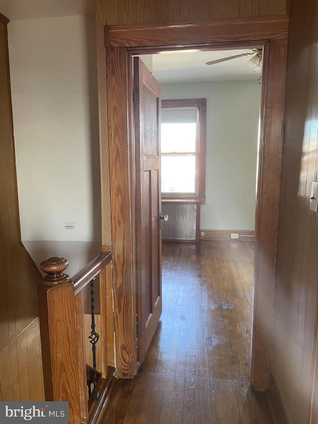 corridor featuring hardwood / wood-style floors and baseboards