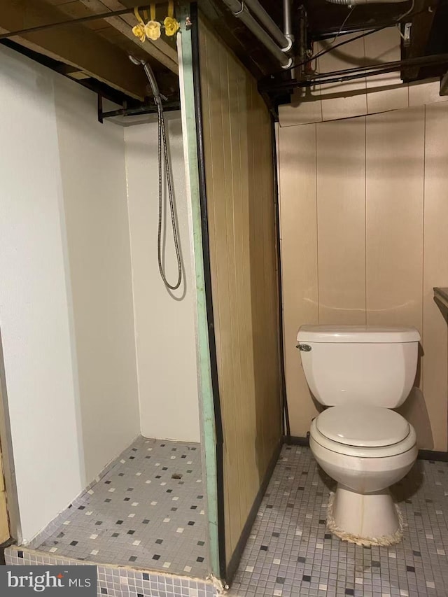 full bathroom with toilet, walk in shower, and tile patterned flooring