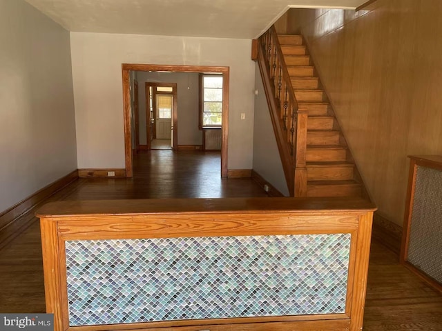 stairway with baseboards and wood finished floors