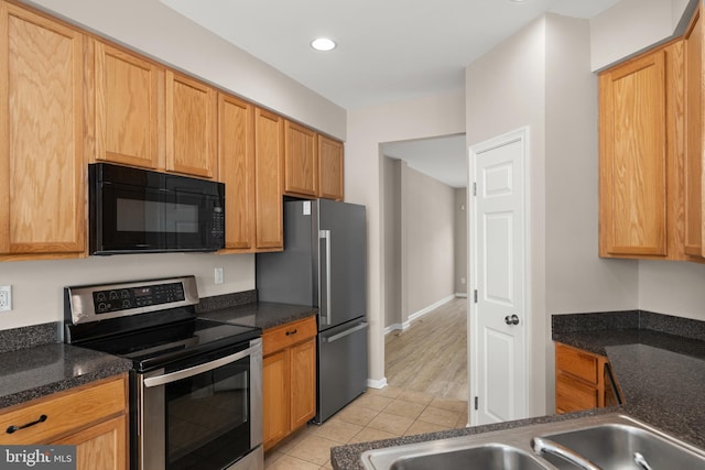 10023 Iron Pointe Drive Ext Unit 201B2, Millsboro, DE 19966 - kitchen featuring appliances with stainless steel finishes, light tile patterned floors, dark stone countertops, and recessed lighting