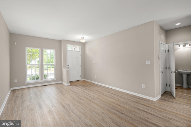 10023 Iron Pointe Drive Ext Unit 201B2, Millsboro, DE 19966 - unfurnished living room with light wood-style flooring, baseboards, and a sink