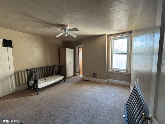 unfurnished bedroom with visible vents, ceiling fan, baseboards, carpet floors, and a textured ceiling
