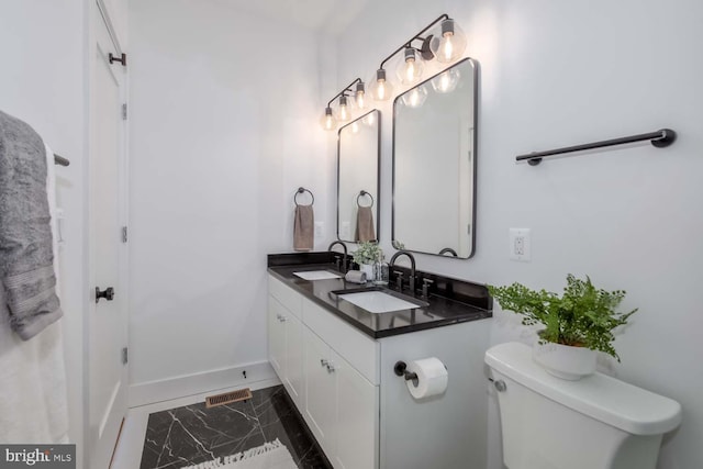 426 Manor Pl NW Unit 3, Washington, DC 20010 - bathroom featuring baseboards, toilet, marble finish flooring, and double vanity