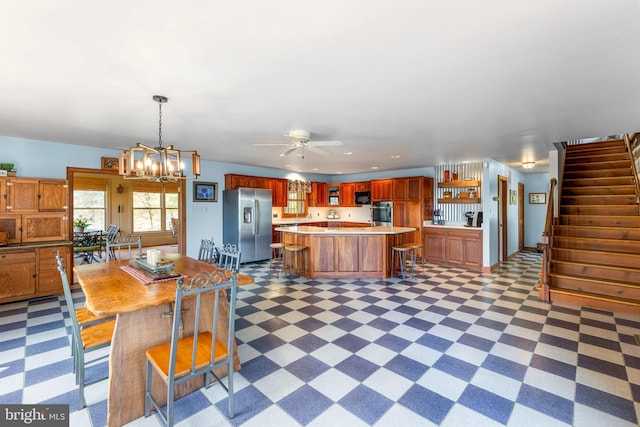 1460 Pitcock Ln, Winchester, VA 22602 - kitchen with ceiling fan with notable chandelier, light floors, a kitchen island, light countertops, and stainless steel appliances