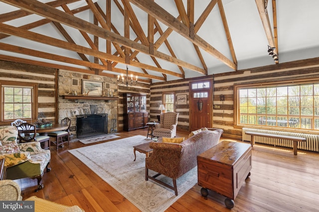 1460 Pitcock Ln, Winchester, VA 22602 - living room with radiator, beamed ceiling, a fireplace, wood walls, and hardwood / wood-style flooring