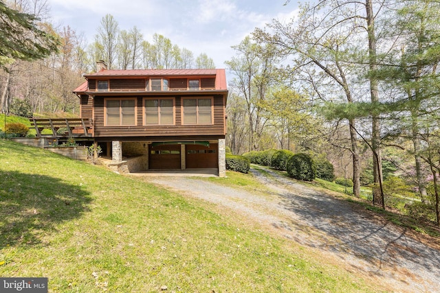 1460 Pitcock Ln, Winchester, VA 22602 - view of front of property with stone siding, metal roof, a garage, dirt driveway, and a front lawn