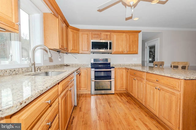 kitchen featuring crown molding, a sink, appliances with stainless steel finishes, a peninsula, and light wood-style flooring