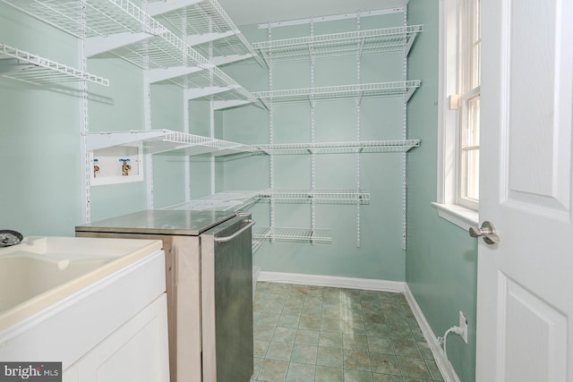laundry room featuring baseboards and a sink