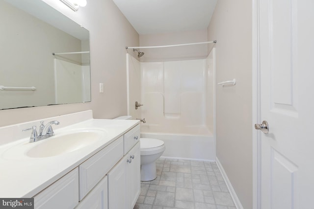 bathroom with toilet, stone finish flooring, vanity, shower / bathing tub combination, and baseboards