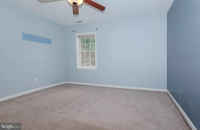 carpeted empty room with a ceiling fan, baseboards, and visible vents